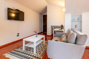 a living room with a couch and a table at Ribeiro´s House, New apartment with amazing sunsets in Arco da Calheta