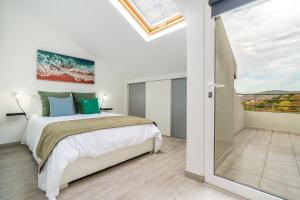 a bedroom with a bed and a sliding glass door at Ribeiro´s House, New apartment with amazing sunsets in Arco da Calheta