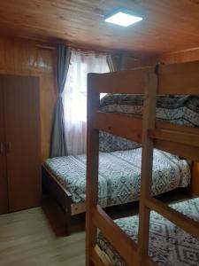 Divstāvu gulta vai divstāvu gultas numurā naktsmītnē Cabañas Naturaleza Boyenar