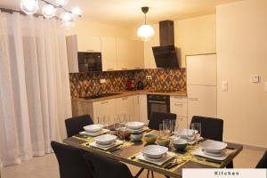 ein Esstisch mit Stühlen und eine Küche in der Unterkunft Appartement cosy aux portes de Disney in Chessy