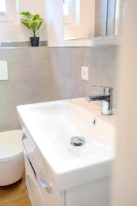 a white bathroom with a sink and a toilet at Premium Zuhause - Seeblick, Balkon, Pool & Seepromonade in Langscheid +26 photos