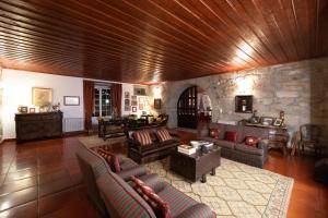 a large living room with couches and a stone wall at Casa do Cimo in Aldeia Nova do Cabo