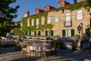 an outdoor venue with tables and chairs in front of a building at Casa do Cimo in Aldeia Nova do Cabo