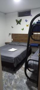 1 dormitorio con 1 cama con mariposas en la pared en HOTEL DEPARTAMENTAL, en Ibagué