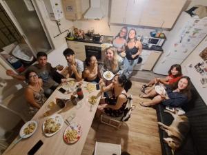 un grupo de personas sentadas alrededor de una mesa en una cocina en Hostel El Cascabel, en Granada