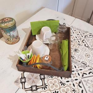 bandeja de madera con tazas y utensilios sobre una mesa en Au Petit Nid de Sanguinet, en Sanguinet 2 fotos más