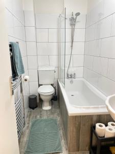 a bathroom with a toilet and a tub and a sink at King's Cross in London