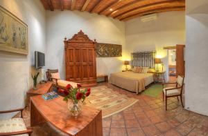 a living room with a room with a bed and a couch at Hotel La Casona de Tita in Oaxaca City