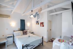 um quarto com uma cama branca e uma mesa em Hotel Selini em Áyios Nikítas