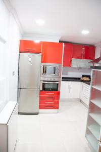 a kitchen with red cabinets and a stainless steel refrigerator at El Balcón de Miguel in Logroño