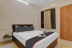 Collection O Hotel Riddhi Siddhi في إندوري: غرفة نوم بسرير كبير وباب خشبي