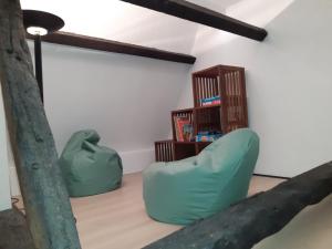 uma sala de estar com uma cadeira verde e uma estante de livros em Het Maelslot (Mechelen) em Mechelen
