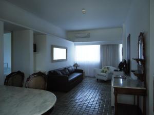 a living room with a couch and a table at Flat no Hotel Imperial Suites in Recife +3 photos