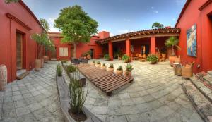 a patio with a wooden bench in front of a building at Hotel La Casona de Tita in Oaxaca City