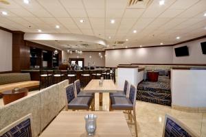 DoubleTree by Hilton Augusta في أوغوستا: مطعم بطاولات وكراسي وبار