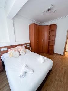 een slaapkamer met een bed met witte lakens en kussens bij El Balcón de Miguel in Logroño
