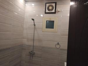 a shower with a shower head in a bathroom at كازا رست للوحدات السكنية in Ḩayy aş Şāliḩīyah