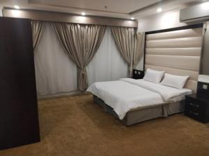a bedroom with a large bed with white sheets and pillows at كازا رست للوحدات السكنية in Ḩayy aş Şāliḩīyah +55 photos