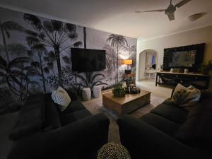uma sala de estar com um sofá e uma televisão de ecrã plano em Off Shore Ballito em Ballito