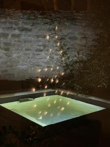 bañera con luces en una pared de piedra en Villa Verde Suite familiale100M2, 2 chambres, terrasse privative Possibilité table d'hôte en Boisseron