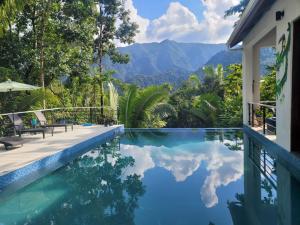 a swimming pool with a view of the mountains at Aracari Lodge & Jungalows in Middlesex