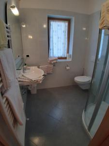 a bathroom with a sink and a toilet and a window at Landgasthof Sonnegghof in Castelvecchio +40 photos