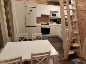 uma cozinha com uma mesa branca e um frigorífico branco em Peuhuntie As 15 em Oulu