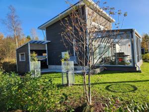 ein kleines Haus in einem Hof mit einem Baum in der Unterkunft Peuhuntie As 15 in Oulu