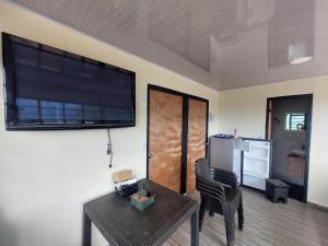 a living room with a large flat screen tv on a wall at GLAMPING EL Mirador in Ibagué