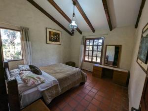 ein Schlafzimmer mit einem Bett und einem großen Fenster in der Unterkunft Rustic lodge Samaipata in Samaipata