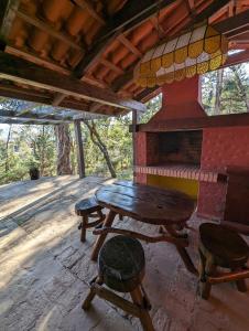 - une table et des chaises en bois sur une terrasse couverte dans l'établissement Rustic lodge Samaipata, à Samaipata