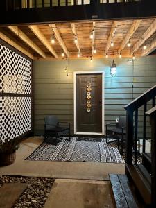 a front porch with a door and two chairs at 2 BR 1 BA apartment in Newnan