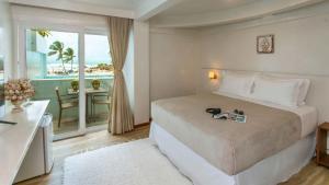 a bedroom with a bed and a view of the ocean at Aqua by Sambass in Morro de São Paulo