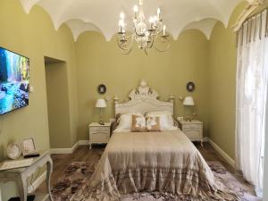 - une chambre avec un grand lit et un lustre dans l'établissement Hotel Boutique IULIA 5 Estrellas Premium, à Zafra