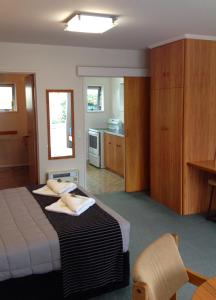 a hotel room with a bed and a kitchen at Aalton Motel in Christchurch