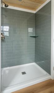 a shower with a white tub in a bathroom at Mini Muskoka Getaway - Huntsville in Huntsville