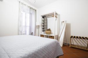 a bedroom with a white bed and a mirror at Ai Bottonai Casa 23 in Palermo