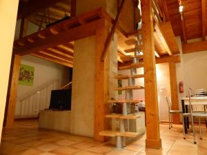 a wooden spiral staircase in a room with a table at Una casa con vistas en Pobes in Pobes