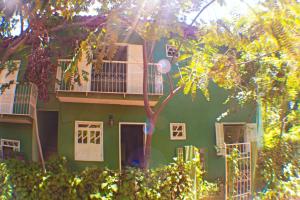un bâtiment verdoyant avec un balcon et un arbre dans l'établissement Casas Caminho Do Meio, à Lençóis
