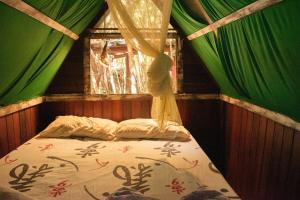a bedroom with a bed with a window and curtains at Lagarto Na Banana Hostel in Pipa