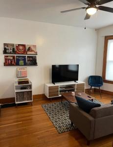 Motown and Henry fords neighbor في ديترويت: غرفة معيشة مع أريكة وتلفزيون بشاشة مسطحة