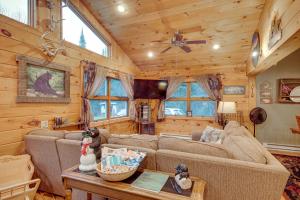a living room with couches and a table in a cabin at 40-Acre, Off-Grid Wakefield Retreat with Gas Grill! in Wakefield