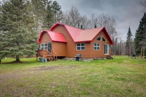 una casa de madera con techo rojo en un campo en 40-Acre, Off-Grid Wakefield Retreat with Gas Grill!, en Wakefield