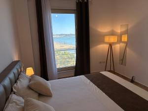 um quarto com uma cama e uma grande janela em Beach front Superior Apartment em Durrës