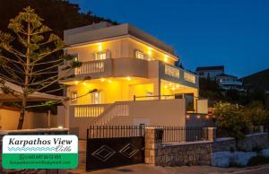 una gran casa blanca con luces encendidas por la noche en Karpathos View Villa, en Karpathos