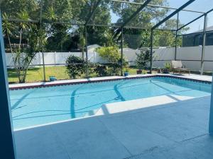 une grande piscine entourée d'une couverture claire dans l'établissement 4 Bedrooms/Arcade/Heated Pool and Beach, à Palm Harbor