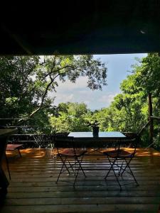 een tafel en stoelen op een patio met bomen bij cabane entre les arbres in Deshaies