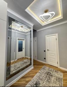 een kamer met een glazen deur en een plafond bij Двухкомнатая элитка Дордой Плаза in Bisjkek