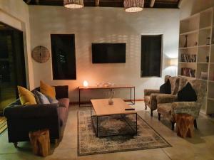 a living room with couches and a coffee table at Kingfisher Creek Safari Lodge in Hoedspruit