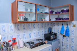 uma cozinha com um balcão com um fogão e armários em Kate's 1 bedroom furnished apartment em Kisumu